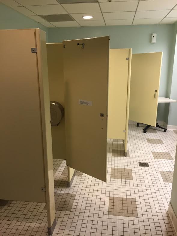 Restroom stalls and finished tile floor — image 5